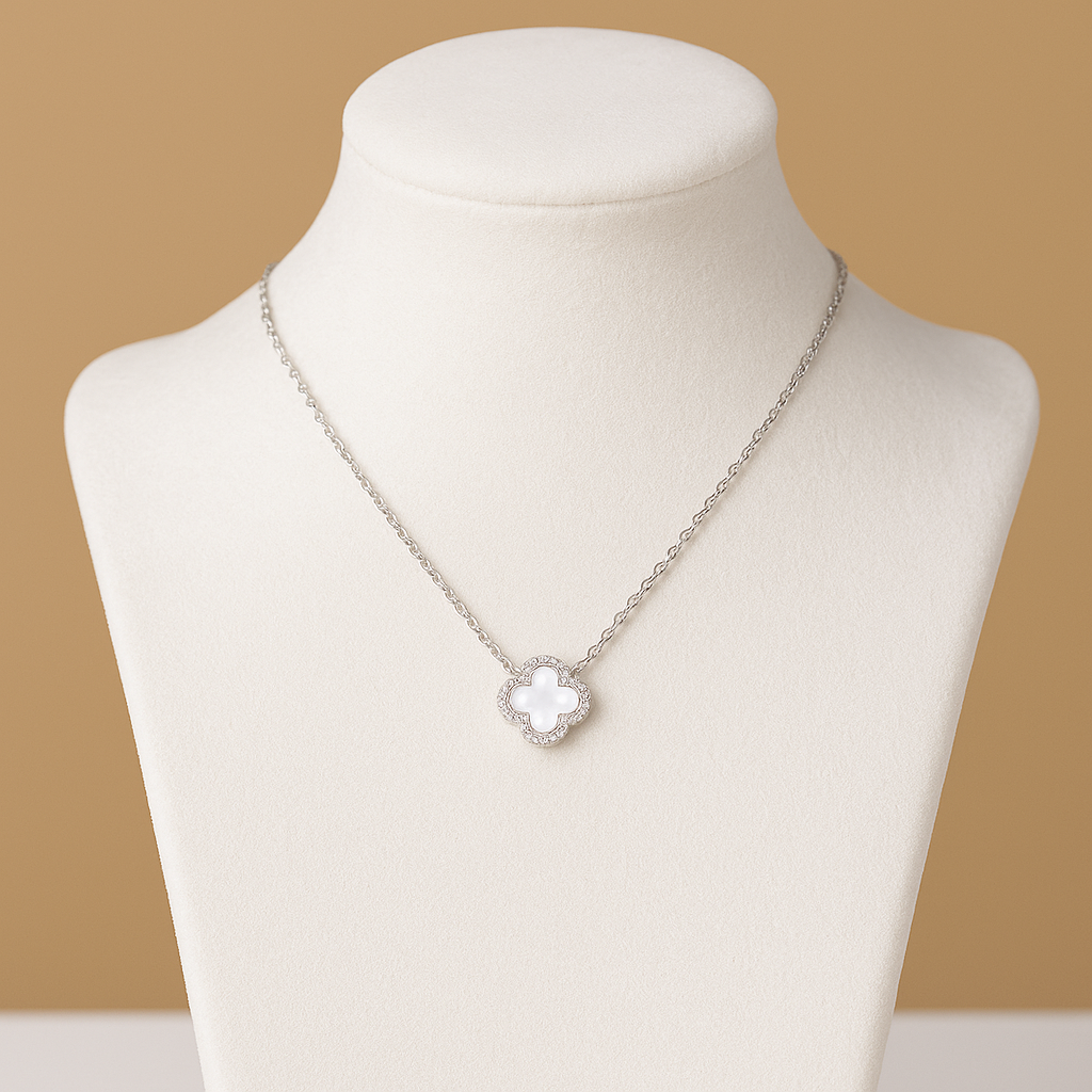 Silver necklace with a cross pendant on a mannequin bust against a beige background