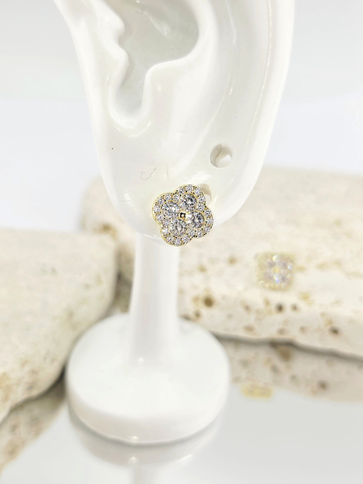 Silver heart-shaped earring on a white stand with seashells in the background danavi aurum