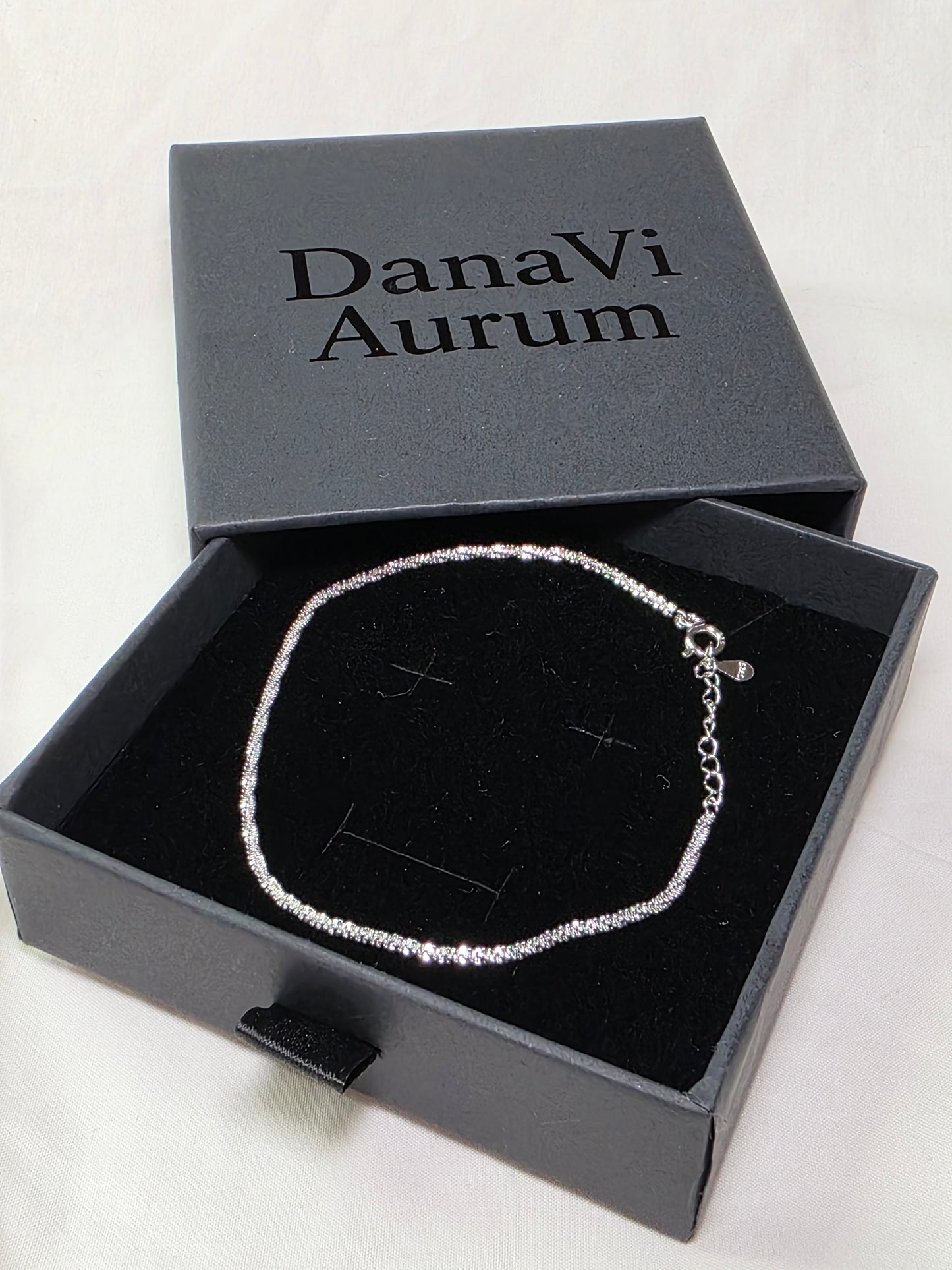 Silver necklace in an open DanaVi Aurum box on a white background