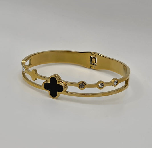 Gold bracelet with a black clover design on a light gray background danavi aurum