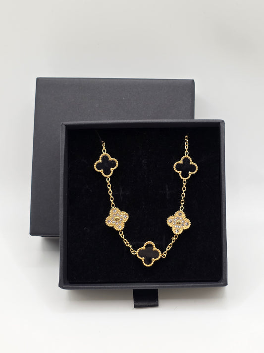 Gold necklace with clover-shaped links in a black jewelry box on a white background Danavi Aurum