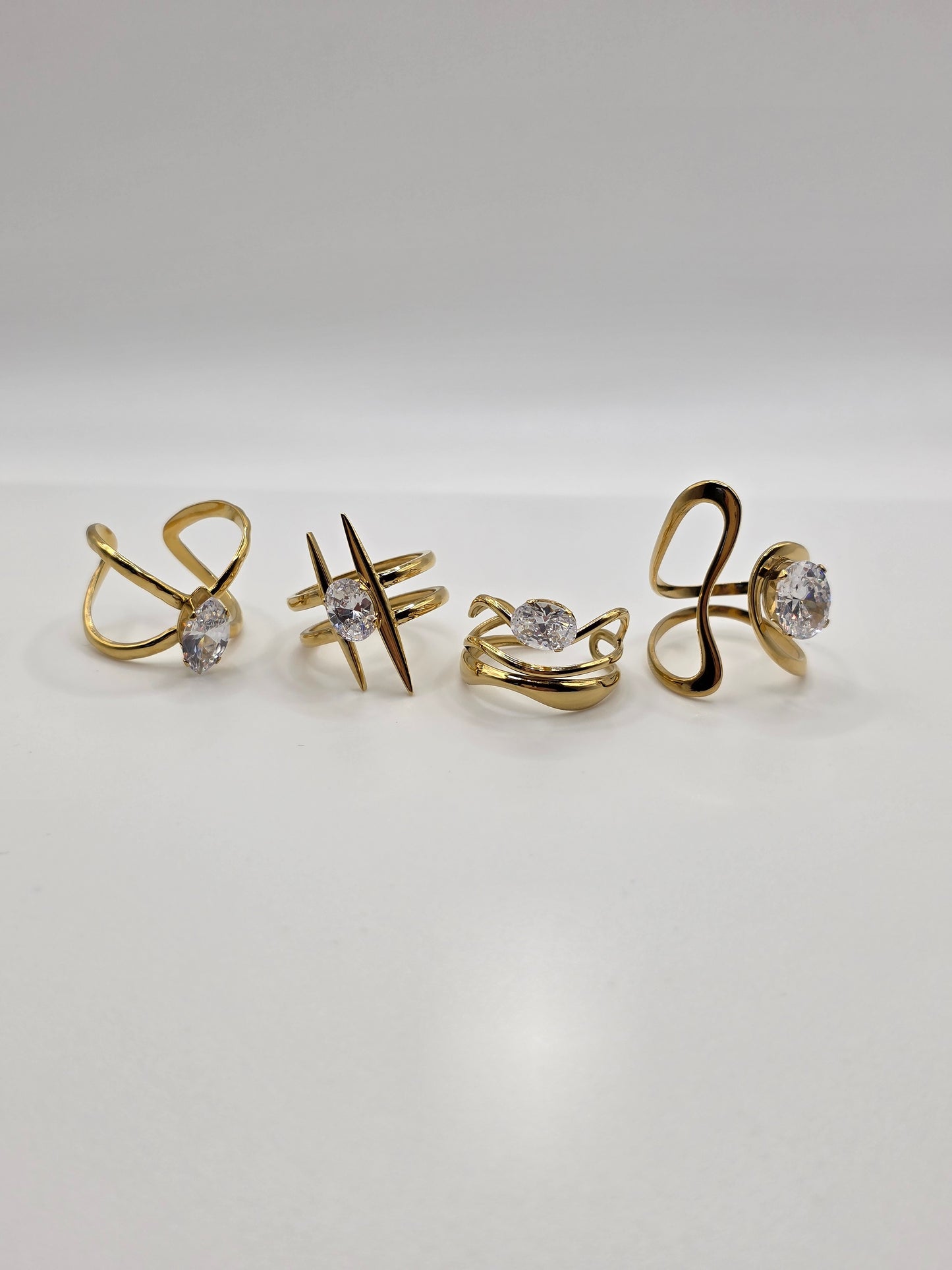 Set of gold earrings with gemstones on a light gray background Danavi Aurum