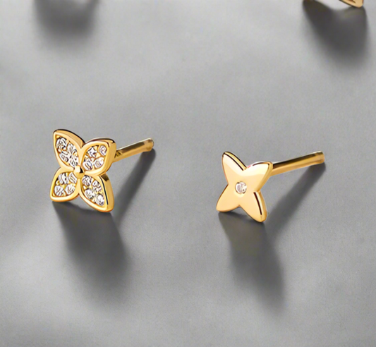 Gold butterfly and star-shaped earrings on a white background