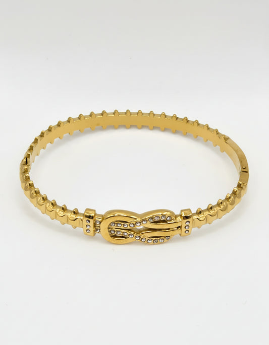 Gold bracelet on a light gray background