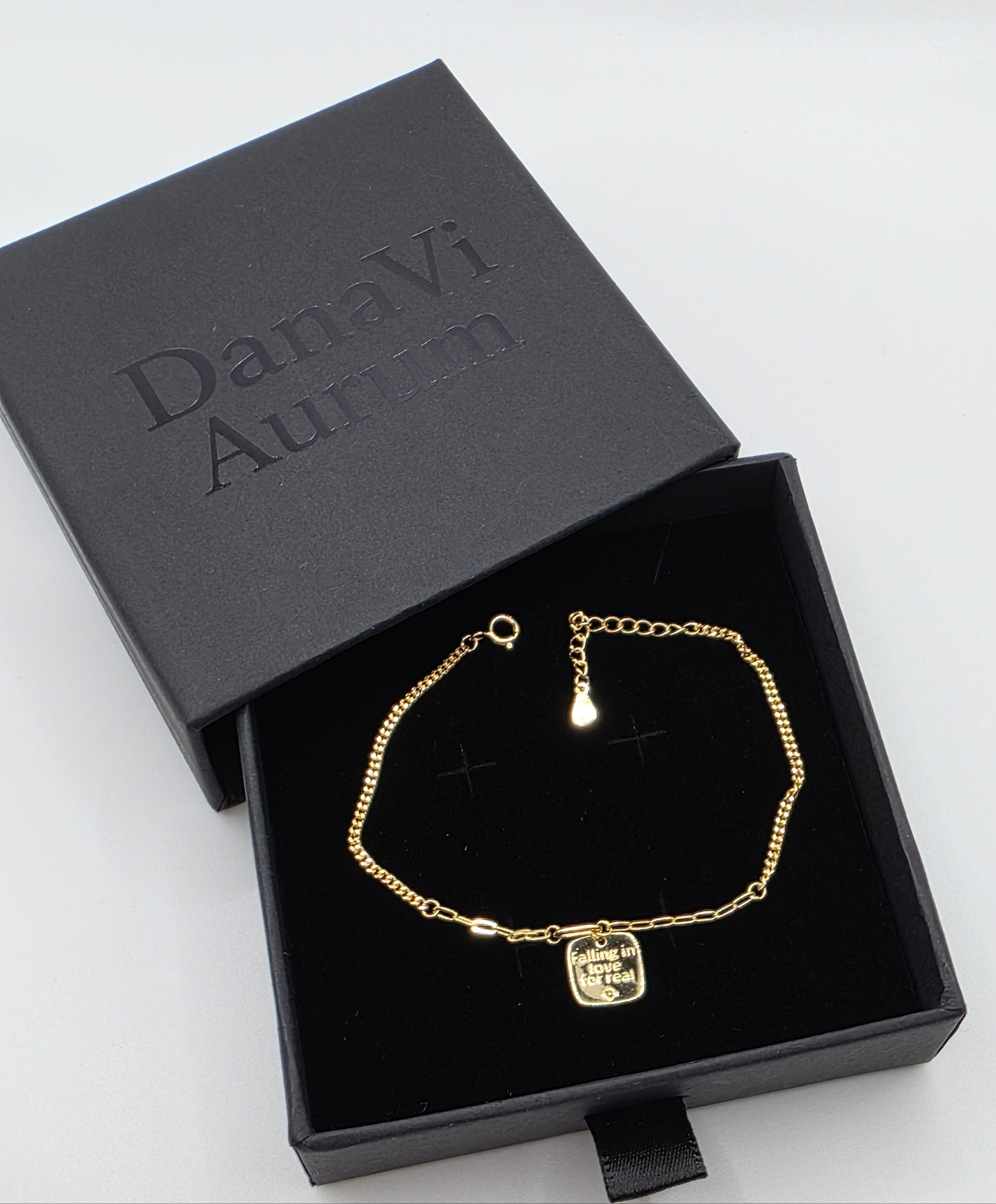 Gold bracelet in a black box with 'Danavi Aurum' branding on a white background