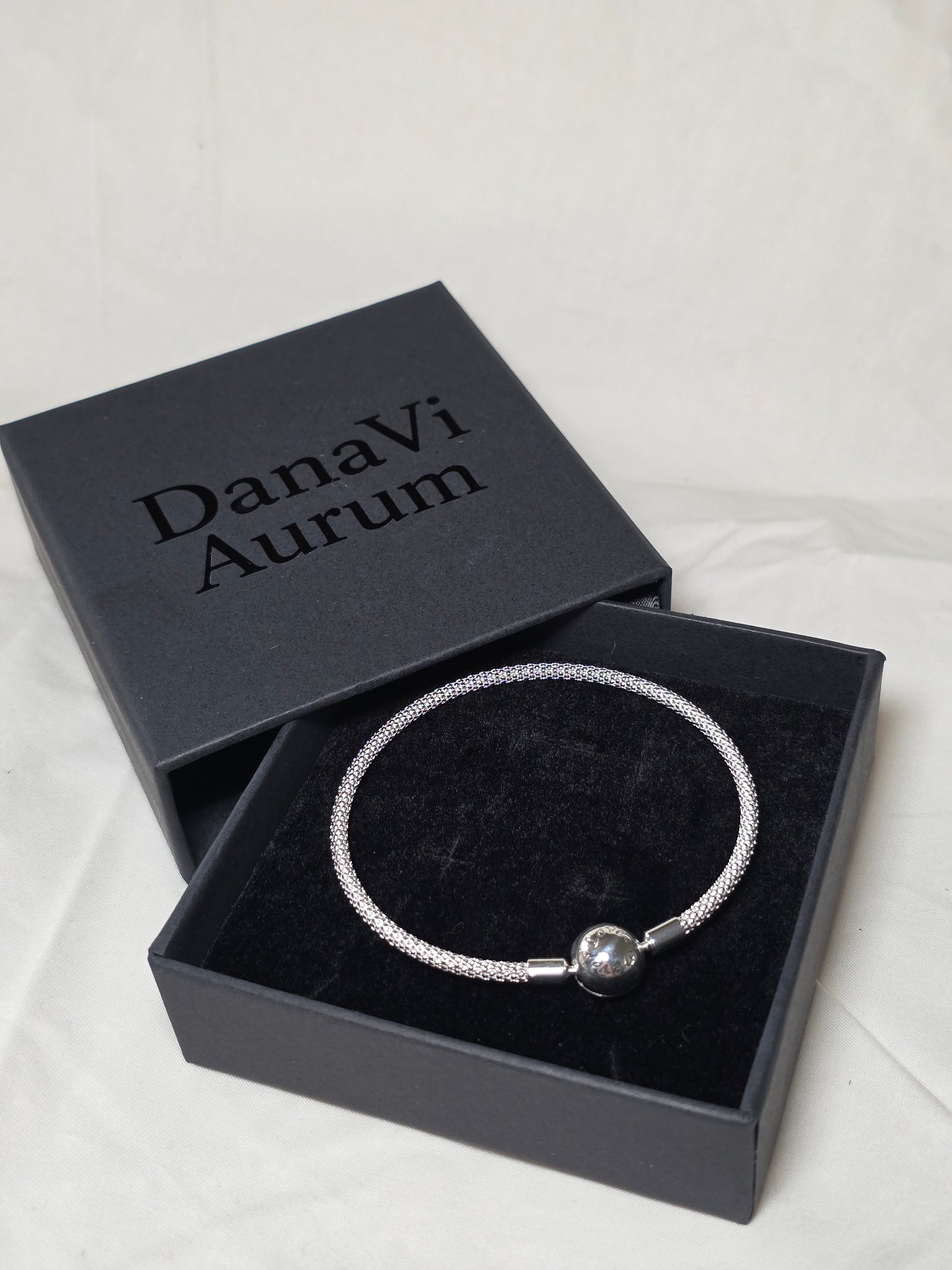 Silver 925 bangle bracelet in a black 'DanaVi Aurum' box on a light background