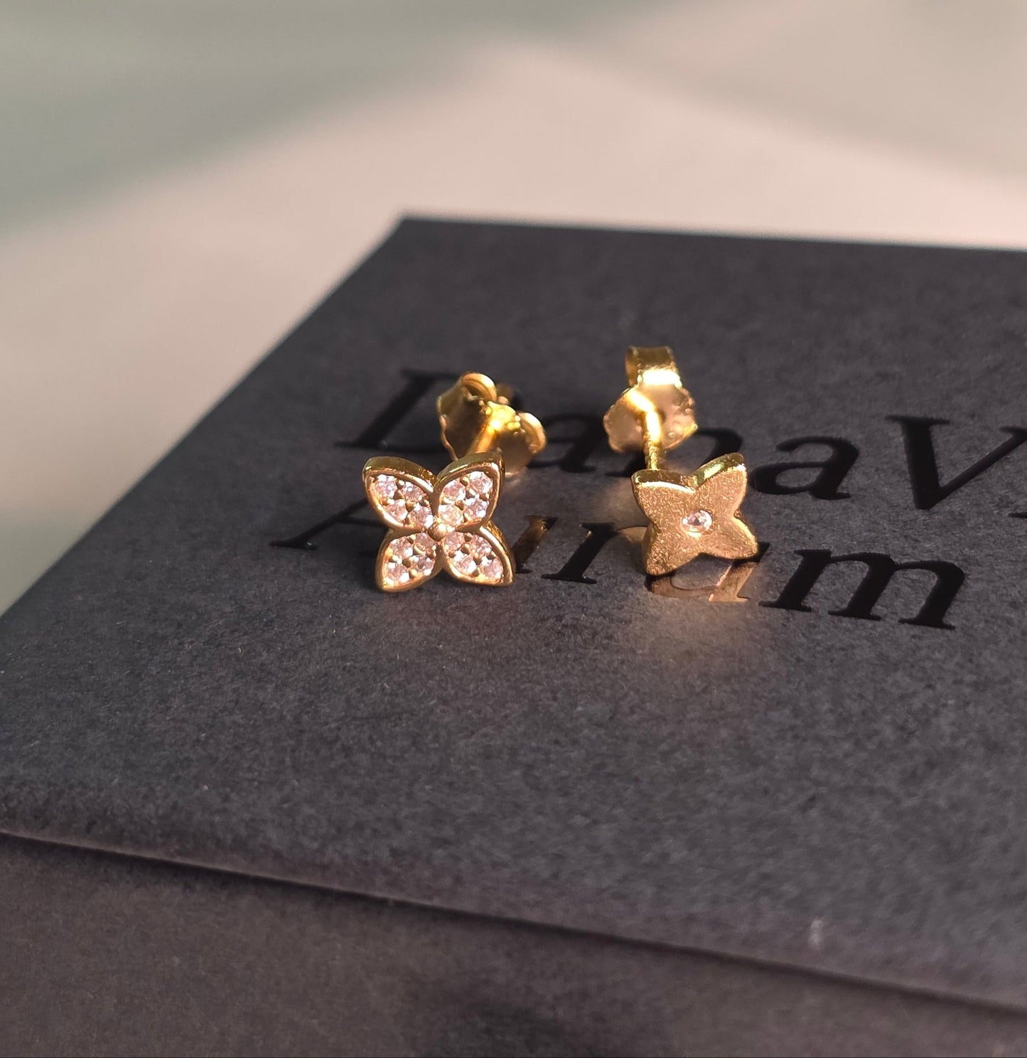 Gold earrings with four leaf clover design on a branded danavi aurum boxd