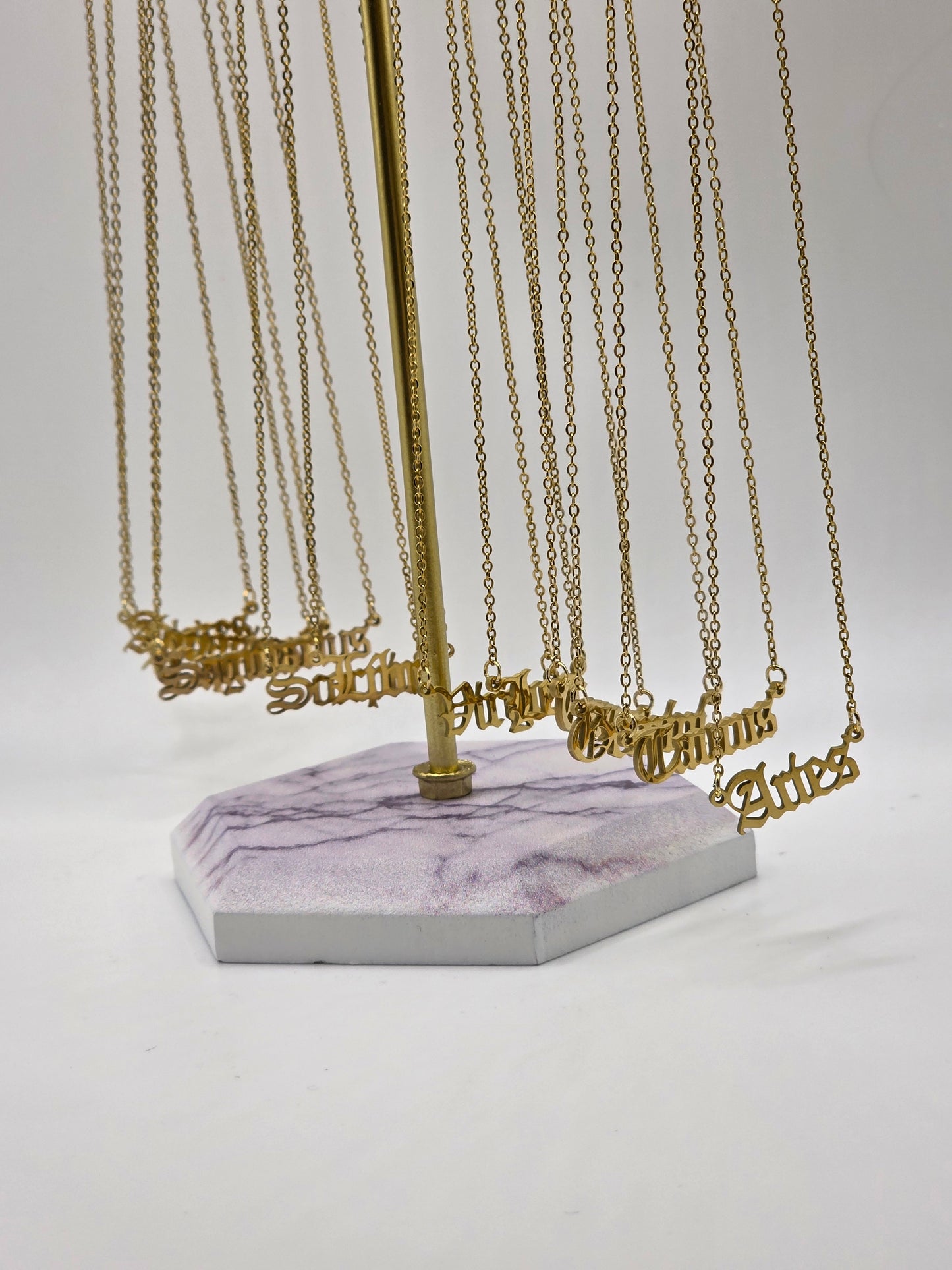 Gold chains hanging from a hook on a white background