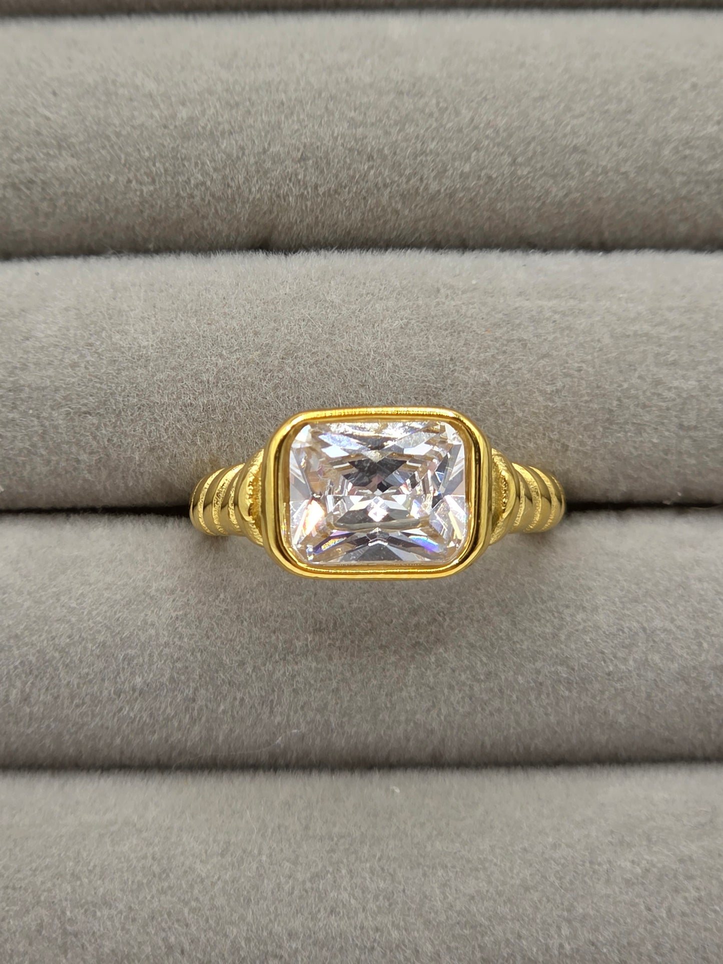 Gold ring with a large diamond on a gray cushion danavi aurum