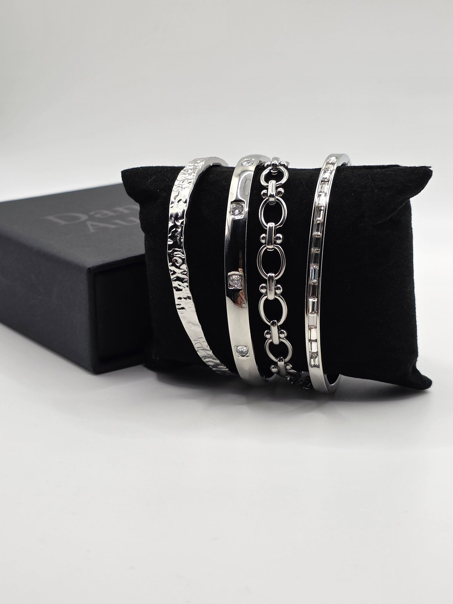 Set of silver bracelets on a black cushion with a white background danavi Aurum