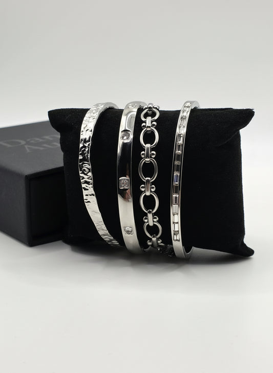 Set of silver bracelets on a black cushion with a white background danavi Aurum