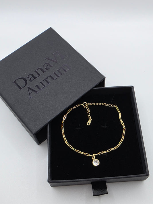 Gold bracelet in a black jewelry box with 'Danavi Aurum' branding on a white background