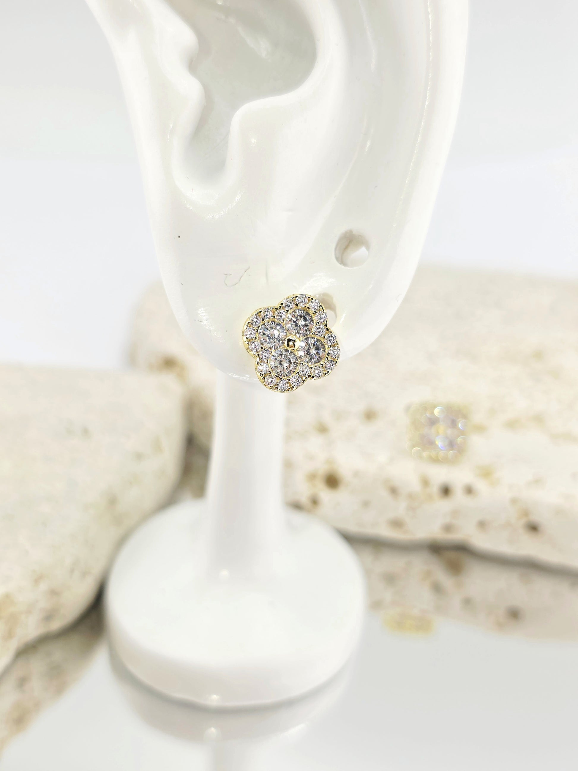 Silver heart-shaped earring on a white stand with seashells in the background danavi aurum