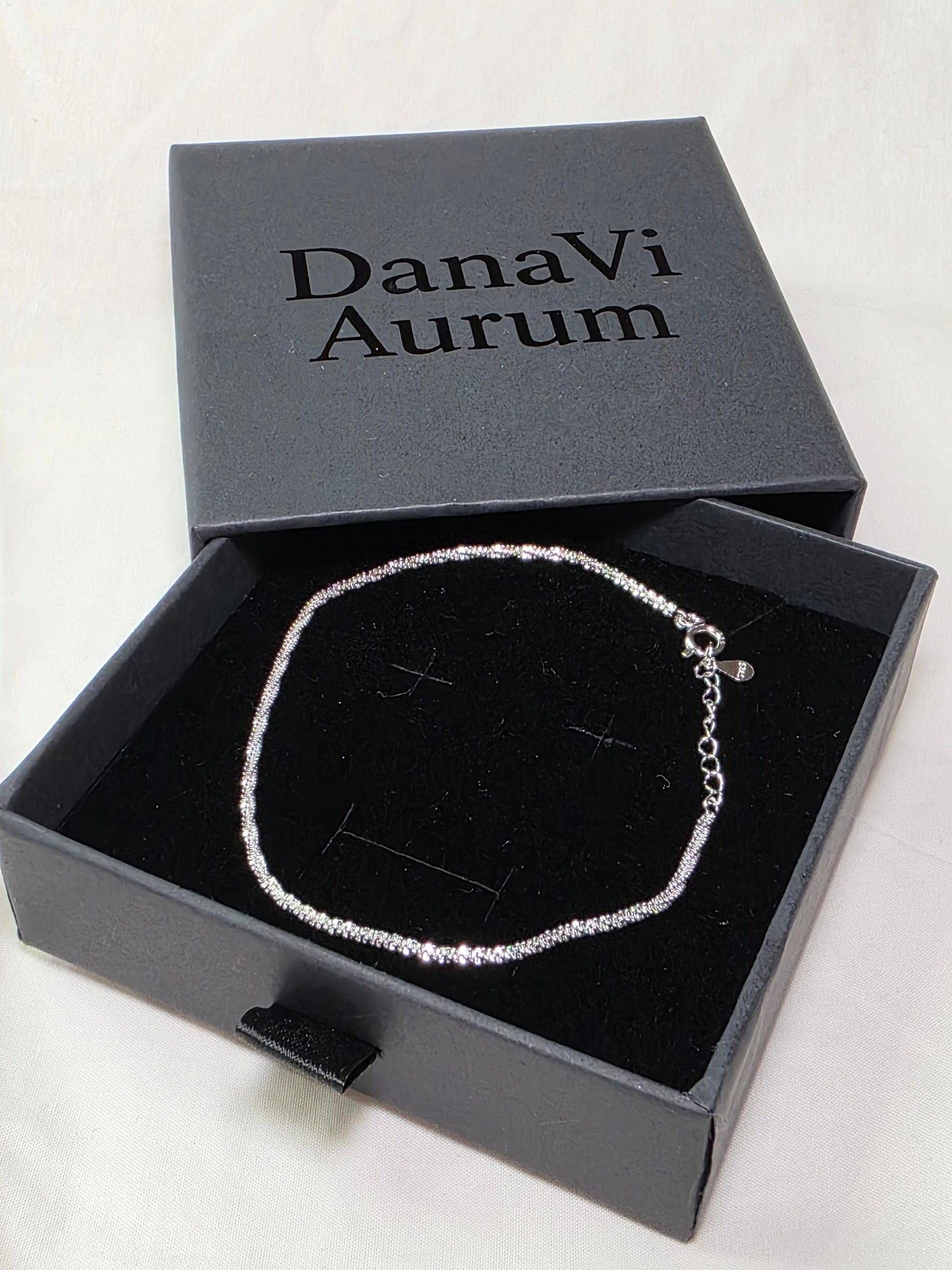 Silver necklace in an open DanaVi Aurum box on a white background