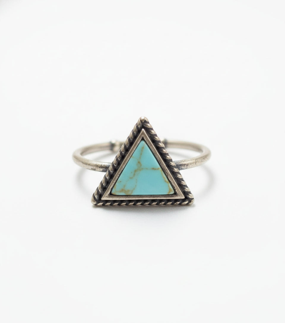 Silver ring with a turquoise triangle stone on a light gray background