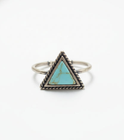 Silver ring with a turquoise triangle stone on a light gray background