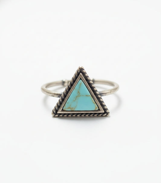 Silver ring with a turquoise triangle stone on a light gray background