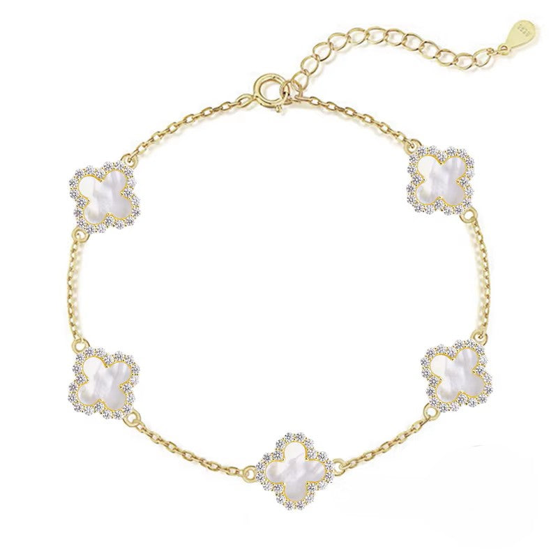 Gold bracelet with floral designs on a white background