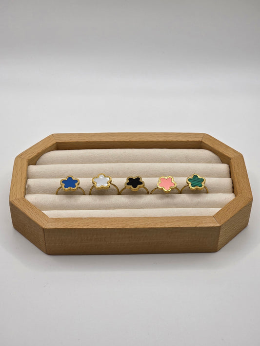 Wooden jewelry display with colorful rings on a white background danavi aurum
