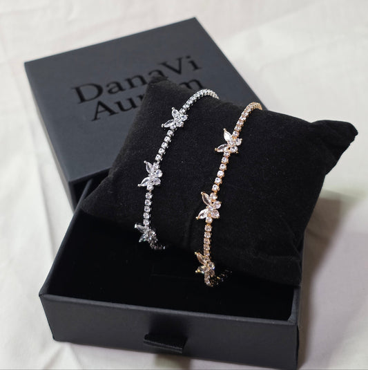 Two butterfly-themed bracelets on a black box with 'Danavi Aurum' branding.