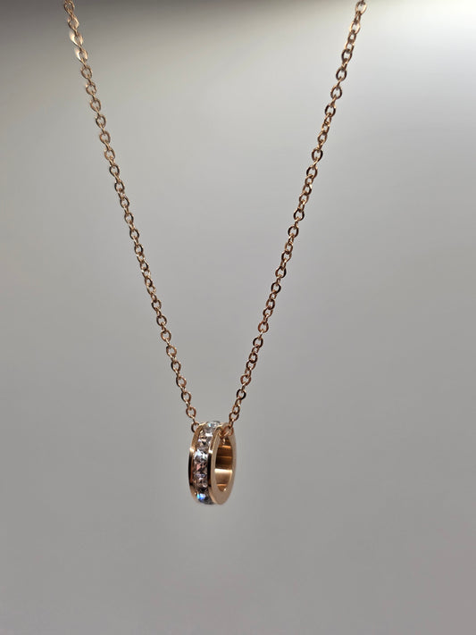 Gold chain with a small ring on a gray background danavi aurum