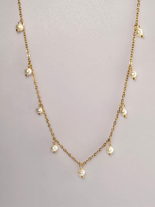 Gold chain necklace with pearls on a light gray background danavi aurum