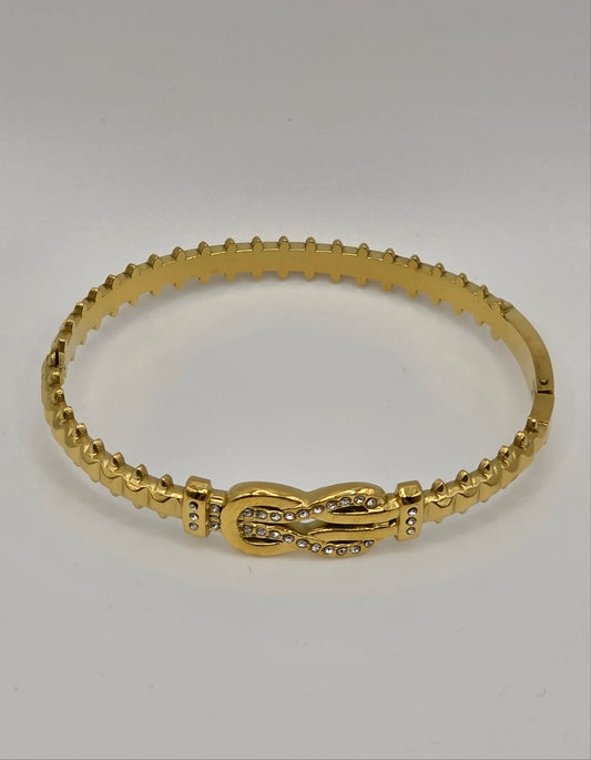 Gold bracelet on a light gray background