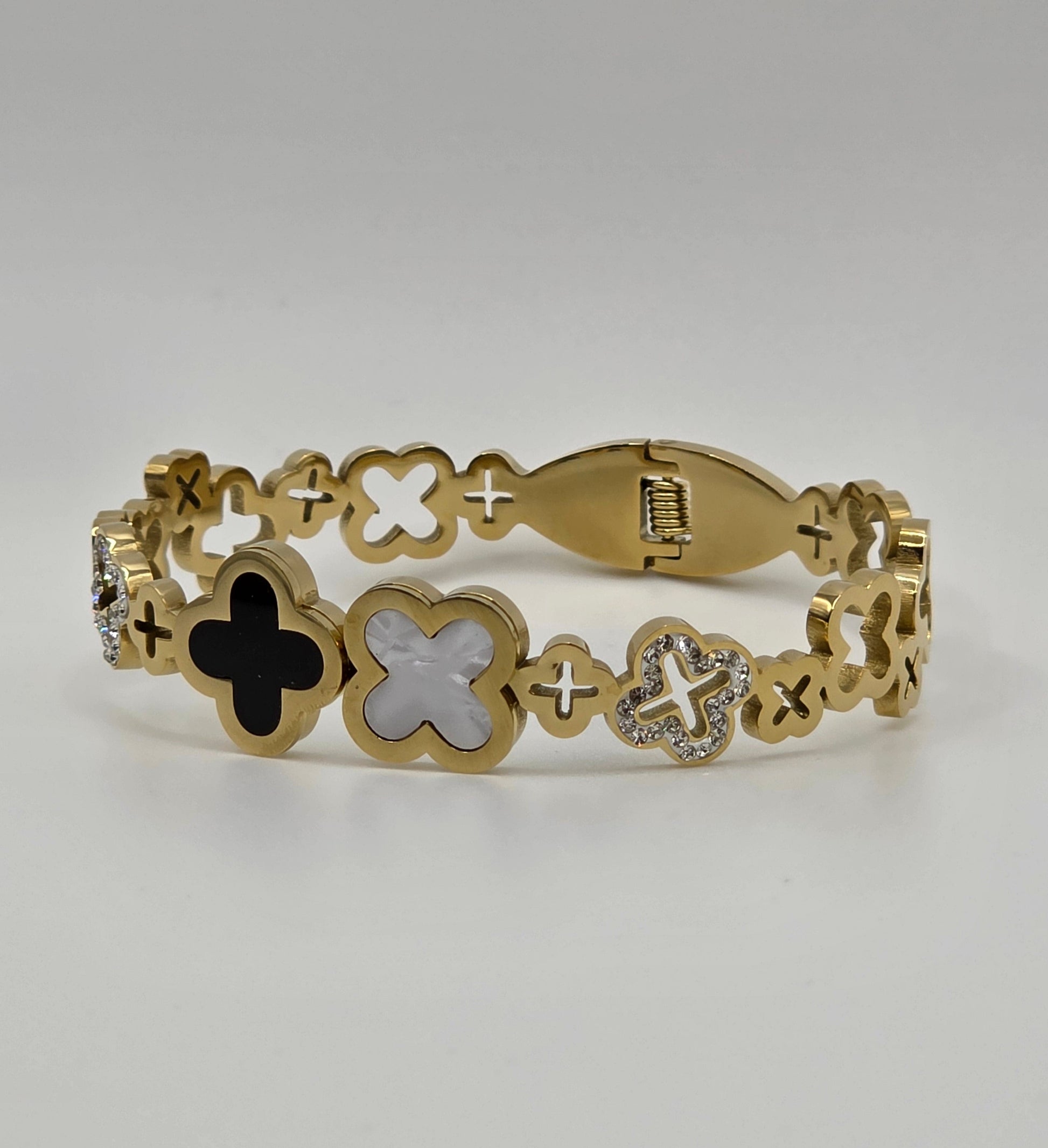 Gold bracelet with intricate designs on a light gray background danavi aurum