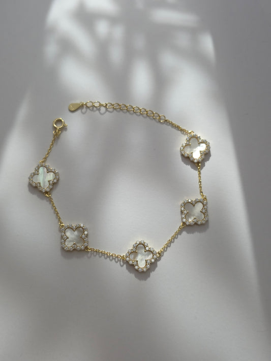 Gold bracelet with floral designs on a light background