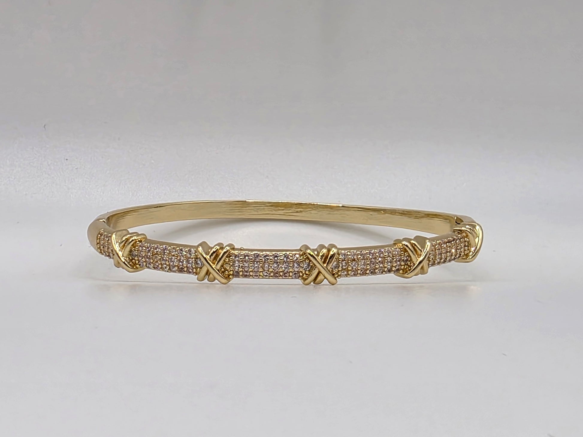 Gold bracelet with interlocking design on a light gray background Danavi Aurum