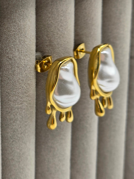 Gold earrings with white stones on a gray surface danavi aurum