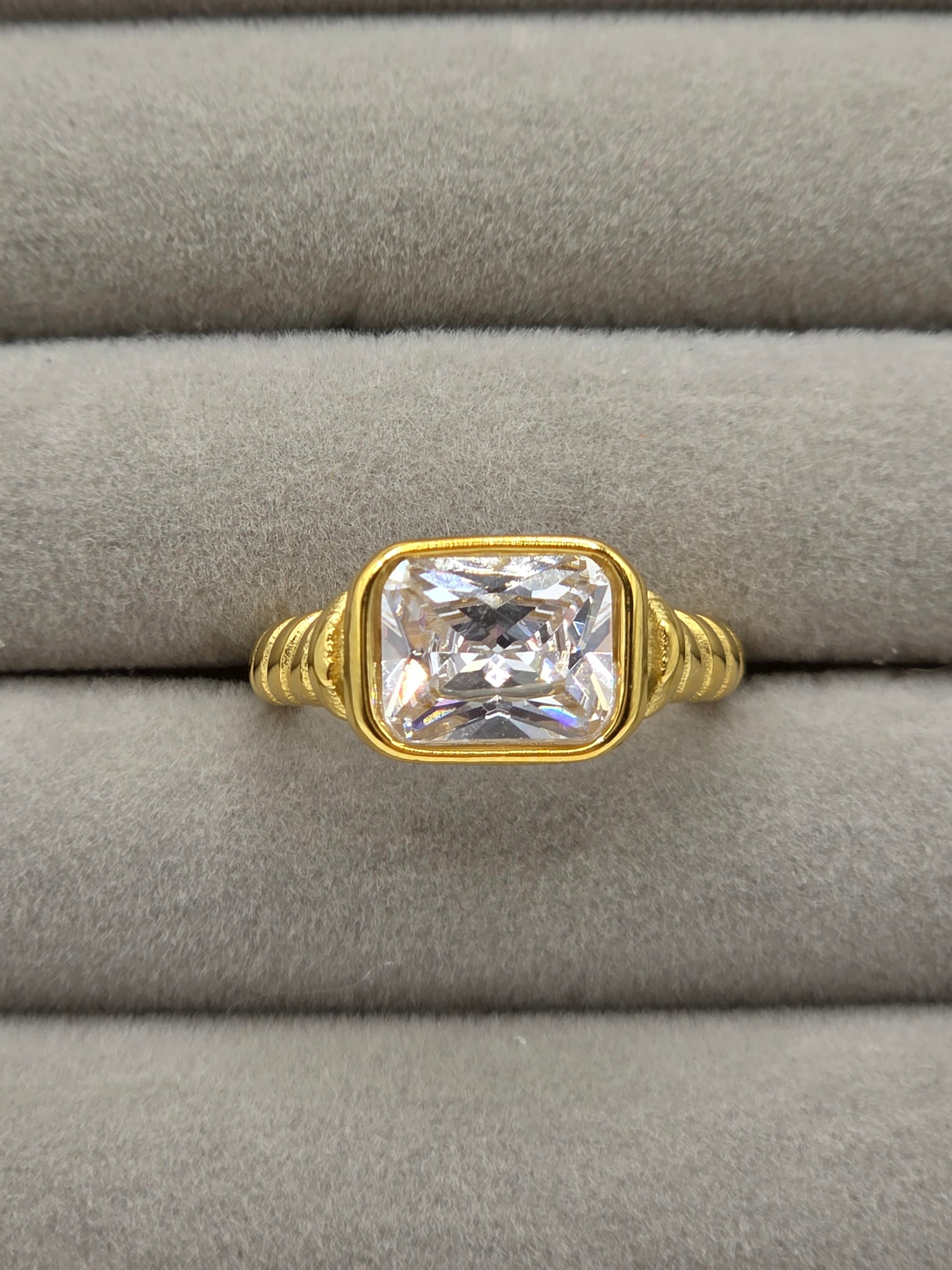 Gold ring with a large diamond on a gray cushion danavi aurum