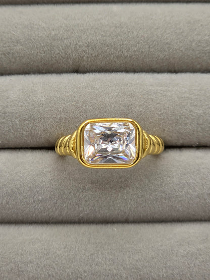 Gold ring with a large diamond on a gray cushion danavi aurum