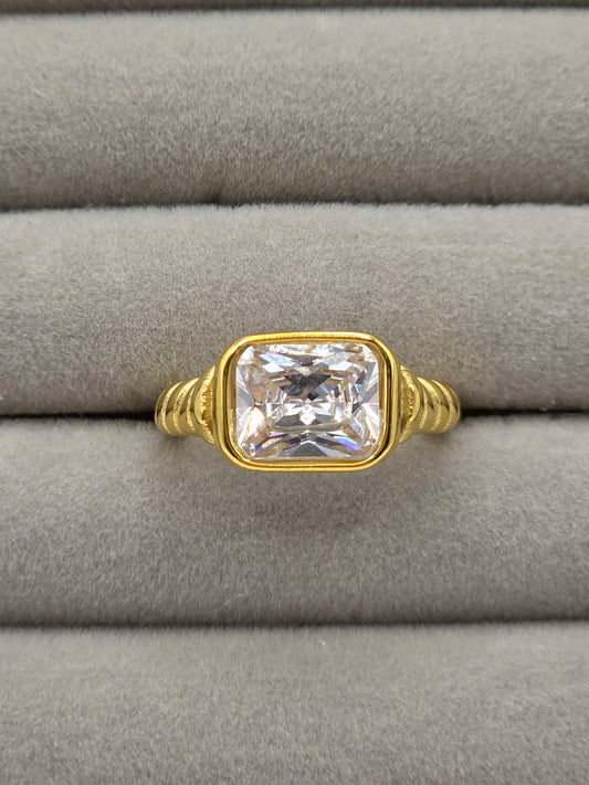 Gold ring with a large diamond on a gray cushion danavi aurum