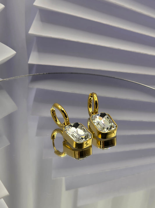 Gold earrings with clear gemstones on a white background danavi aurum