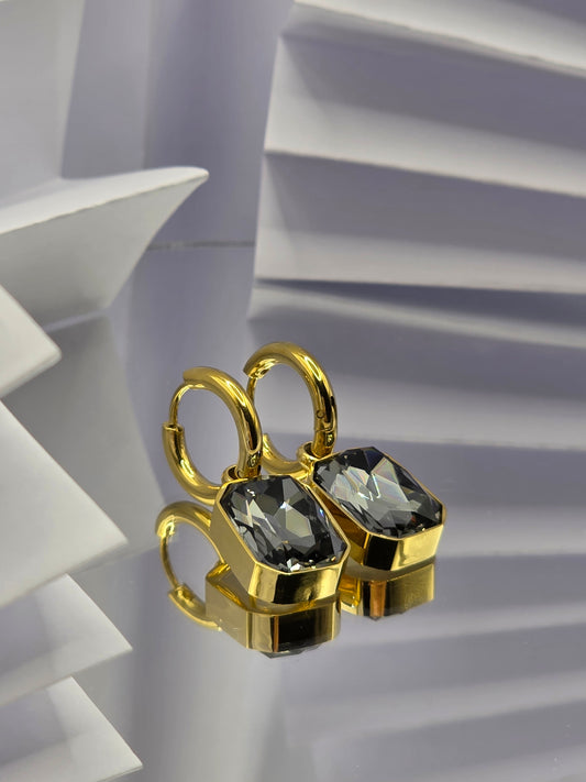 Gold ring with black gemstones on a white geometric background danavi aurum
