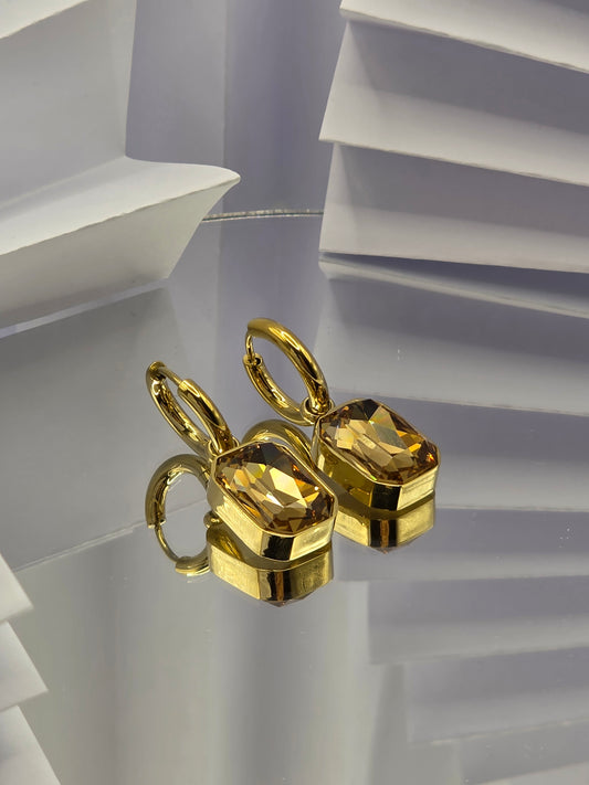 Gold earring on a white background danavi aurum