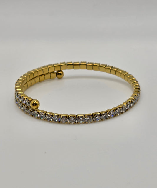 Gold bracelet with embedded stones on a light gray background danavi aurum