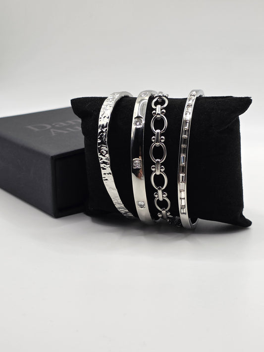 Set of silver bracelets on a black cushion with a white background danavi Aurum
