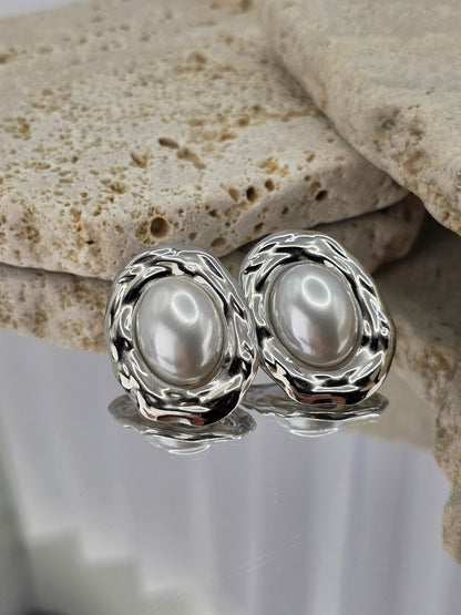 Silver earrings with pearls on a stone surface danavi aurum