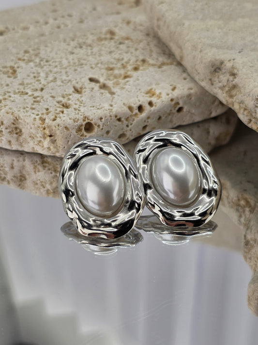 Silver earrings with pearls on a stone surface danavi aurum