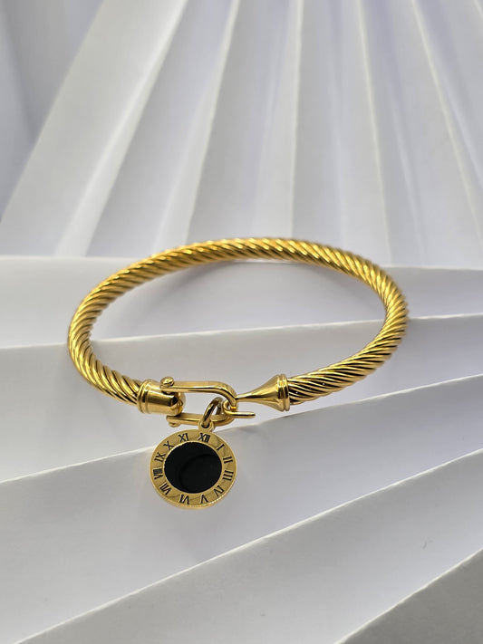 Gold bracelet with a black center stone on a white background danavi aurum
