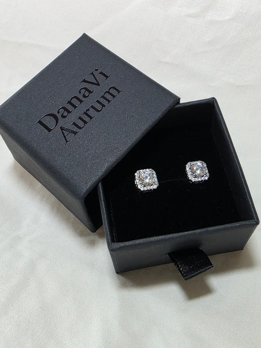 Diamond earrings in a black jewelry box with 'Danavi Aurum' branding on a light gray background