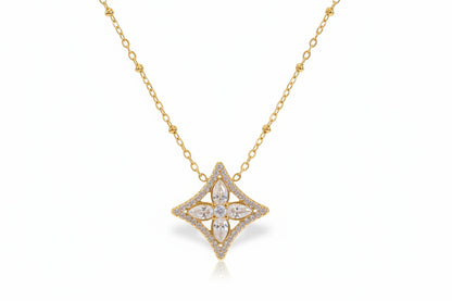 Gold necklace with a star-shaped pendant on a light background
