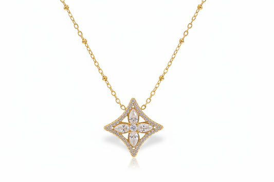 Gold necklace with a star-shaped pendant on a light background