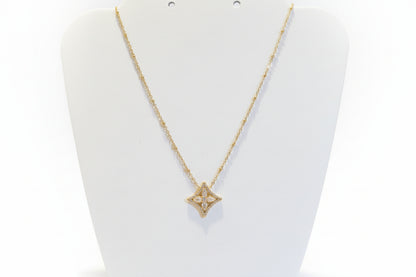 Gold necklace with a star-shaped pendant on a white background