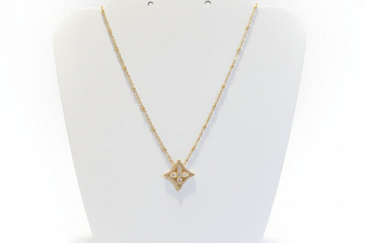 Gold necklace with a star-shaped pendant on a white background