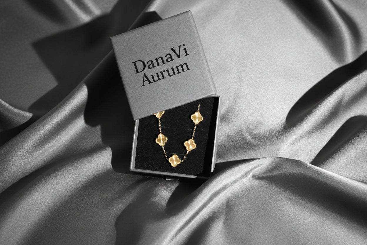 Gold necklace in a DanaVi Aurum box on a dark fabric background